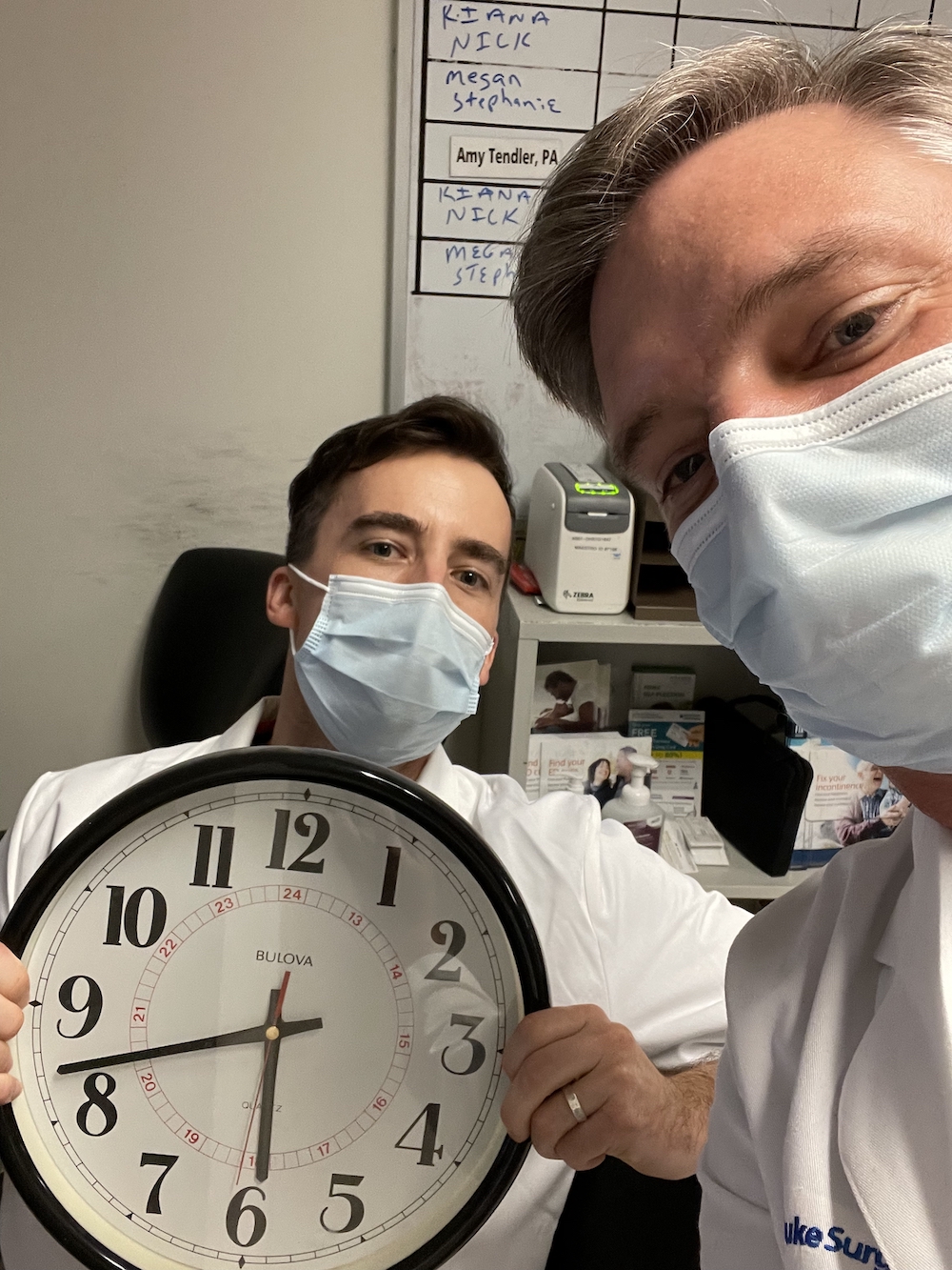 Dr. Peterson and Dr. Krughoff in clinic holding clock
